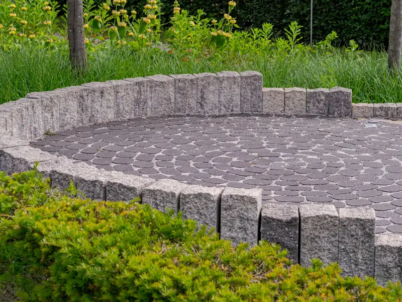 Circular paver patio with a low stone seat wall